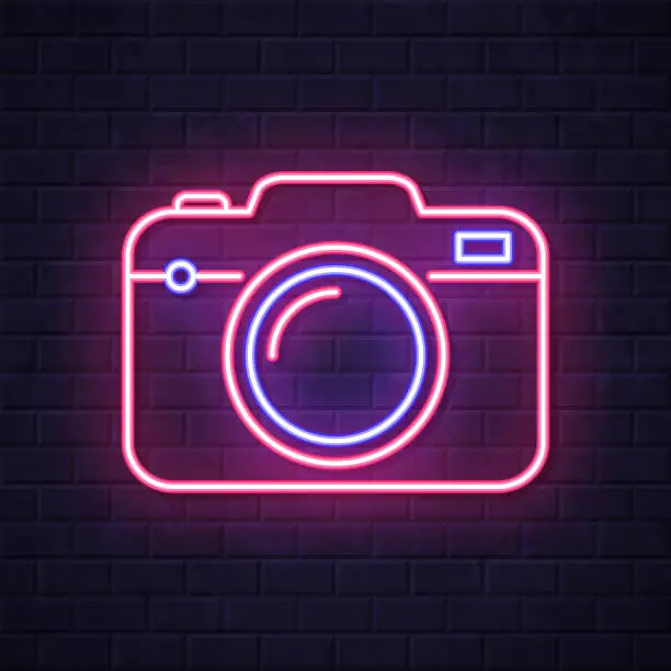 Vector illustration of Camera. Glowing neon icon on brick wall background