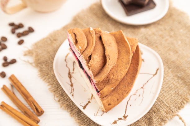 Zephyr or marshmallow cake with cup of coffee on white wooden background and linen textile. side view, close up, selective focus.