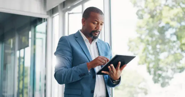 Photo of Business man, tablet and typing for office stock market, investment planning and reading or financial research. Professional african person or trader on digital technology, trading and data analysis