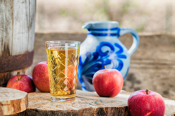 Hessian Bembel Apfelsaft apple cider with apple and blue jug Traditional hessian cider or apple juice in front of the traditional earthware jug aka Bembel.  Wooden background. hesse germany stock pictures, royalty-free photos & images
