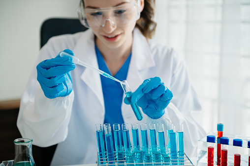 Modern medical research laboratory. female scientist working with micro pipettes analyzing biochemical samples, advanced science chemical laboratory