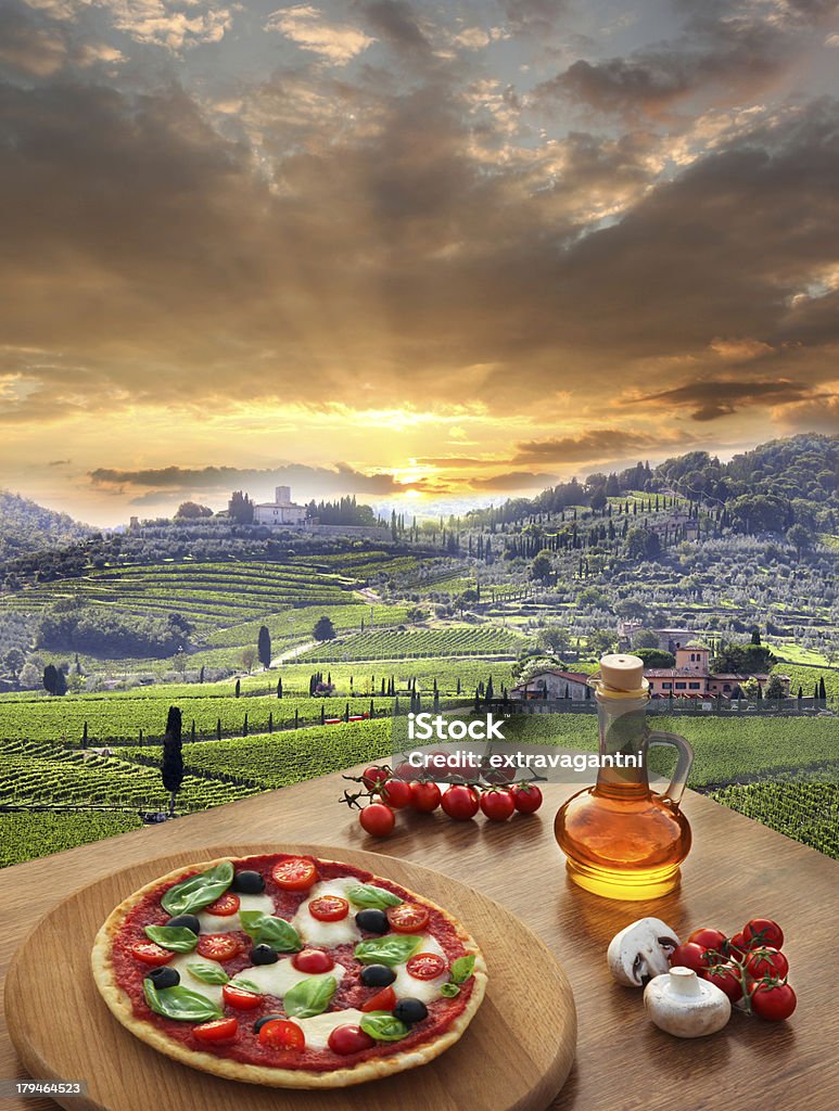 Pizza on a table with a sunset view of a vineyard in Italy Italian pizza in Chianti, famous vineyard landscape in Italy Tuscany Stock Photo