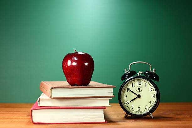 istock Plain School Books, Apple and Clock on Desk at School 179465925