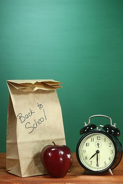 istock Vertical Back to School Lunch, Apple and Clock on Desk 179466138