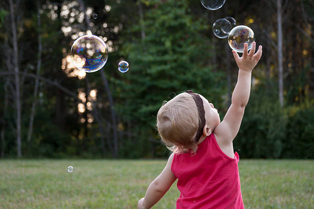Small Child Reaching for Bubbles stock photo