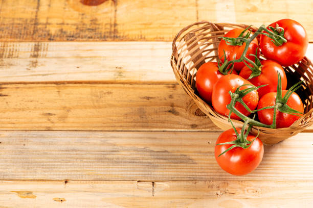 istock Tomatoes, beautiful arrangement with tomatoes in a basket on rustic wood, selective focus. 1794667812