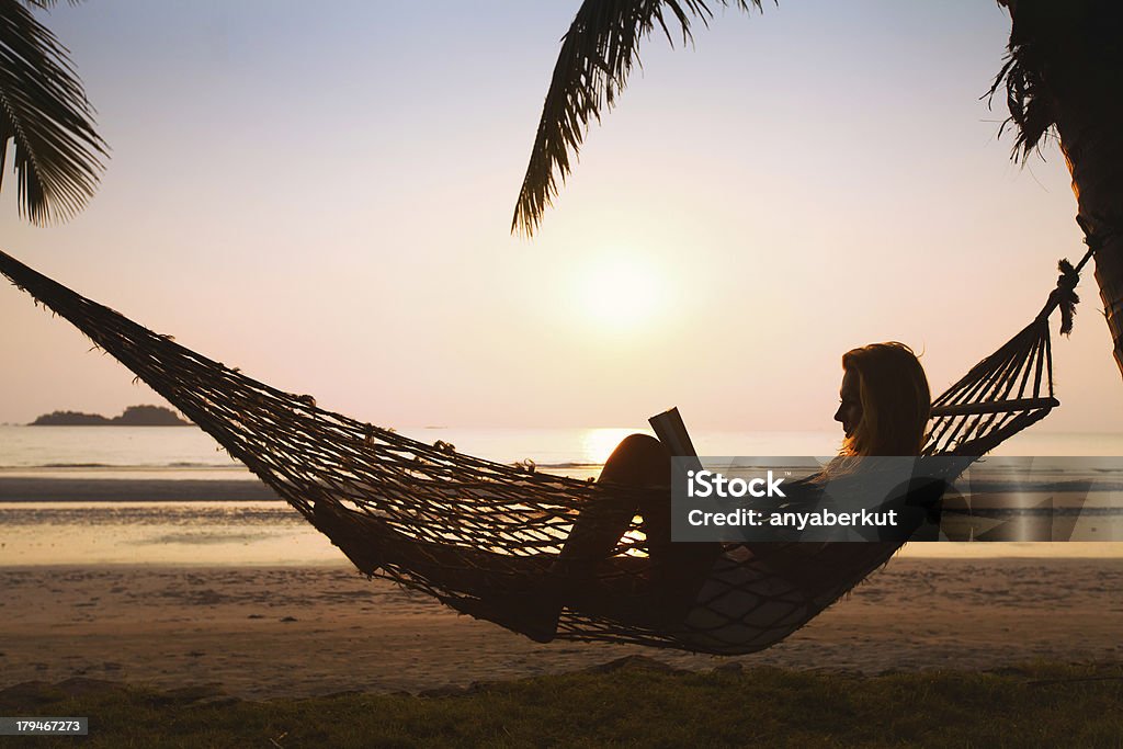 hammock on the beach silhouette of woman relaxing in hammock on the beach Women Stock Photo