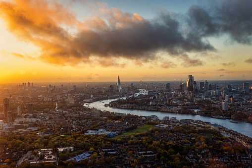 Wide panoramic view over the skyline of London, England, from Battersea along the River Thames until the City during a golden sunset