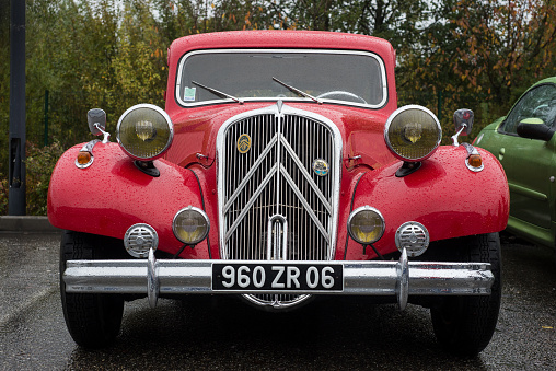Mulhouse - France - 12 November 2023 - Front view of red Citroen traction parked in the street by rainy day