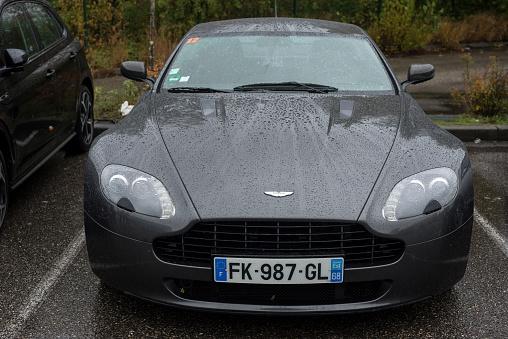 Mulhouse - France - 12 November 2023 - front view of grey Aston martin car parked in the steer by rainy day