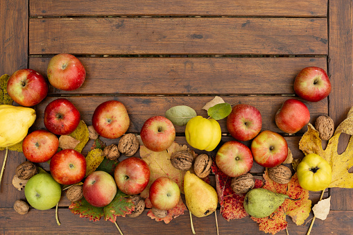 Fall fruit arrangement on a natural wood surface.