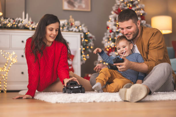 istock Father teaching son how to use remote controlled toy car on Christmas day at home 1794697949