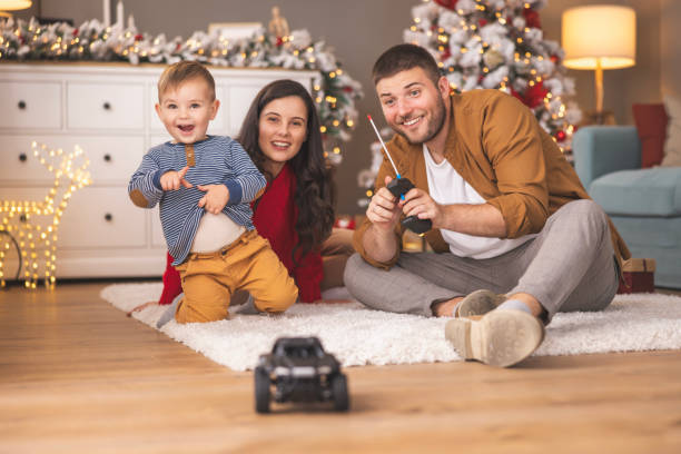 Mother and father playing with their son while spending Christmas day at home