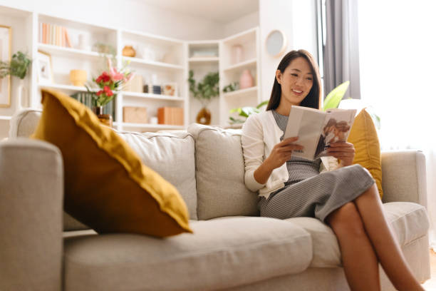 istock Wealthy woman sitting on the sofa and reading a book 1794712601