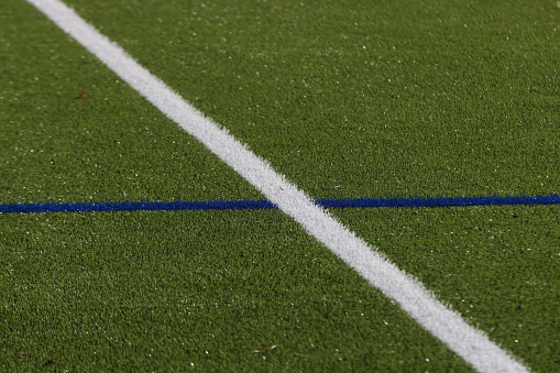 An football field with artificial turf and white linesAn football field with artificial turf and white lines