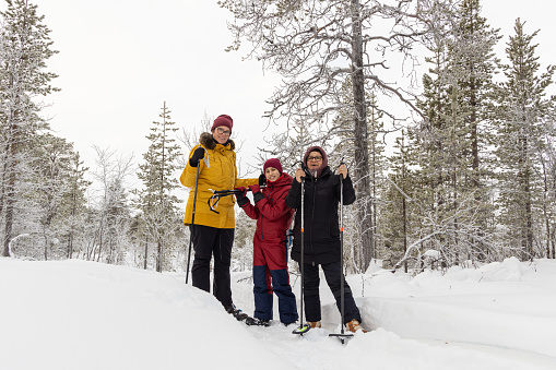Family snowshoeing in the snow in Lapland