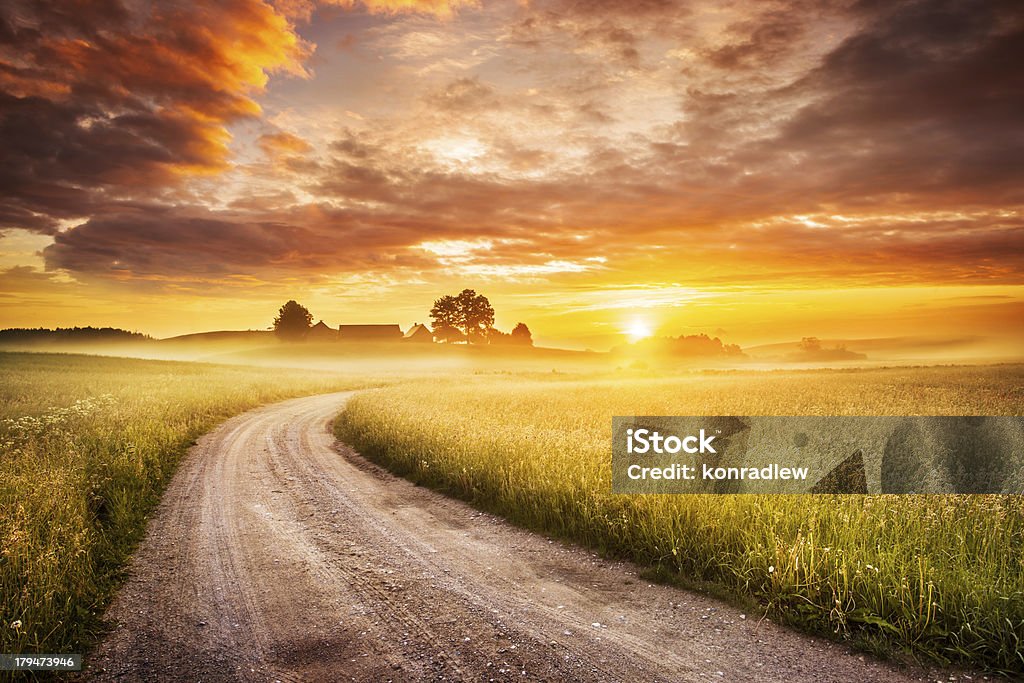 Morning Country Road through the Foggy Landscape - Colorful Sunrise Farm Stock Photo