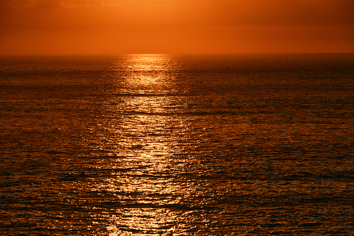 Shimmering sea in orange sun set light from Pentire, Newquay, Cornwall on an early September evening.