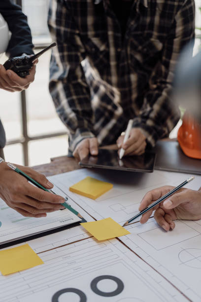 istock Professional architect, designer, team of colleagues discussing project. Building plan design and presentation Construction engineer and worker looking at building model and blueprint plan. 1794751556