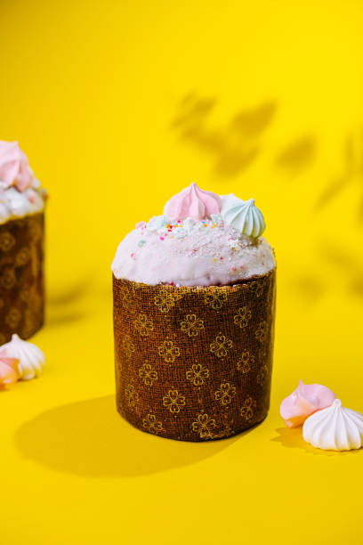Traditional Easter cakes with meringue on yellow background