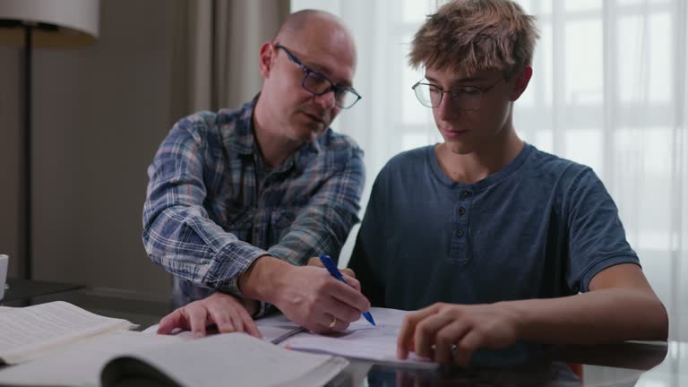 Father helping son to do homework and study at home