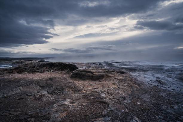 istock a very dark sky and some rocks by the ocean at dusk 1794766942