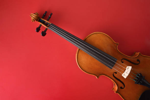 Traditional violin cut diagonally on isolated gradient romantic red background stock photo