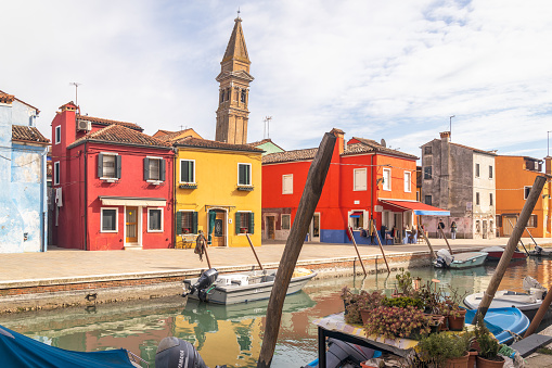 Burano, Italy - March 3, 2023: The island near Venice with a canals between colorful houses.