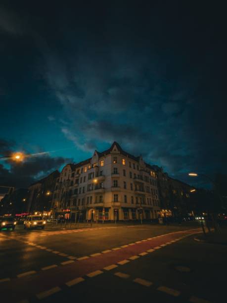 Berlin, Germany – June 23, 2023: A modern building illuminated by street lights against a starry night sky, set in a cityscape