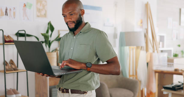 istock Laptop, creative and black man designer check website for orders and stock in a workshop for shipping or delivery. Ecommerce, logistics and businessman with computer for supply chain or distribution 1794788452