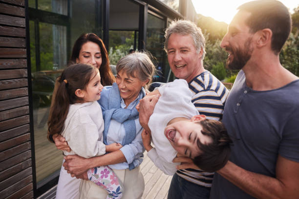istock Laughing multi-generation family standing together in a yard in summer 1794800283