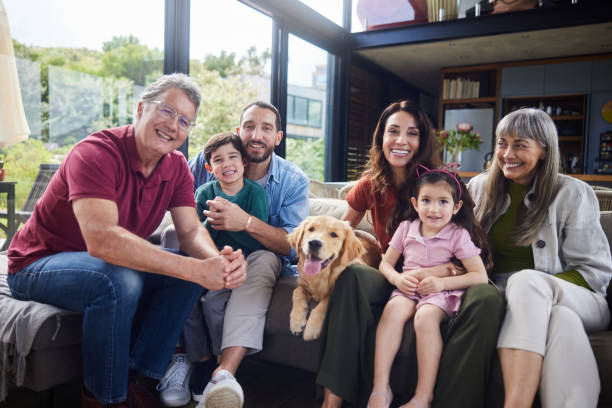 istock Multi-generation family and their dog smiling while on a living room sofa 1794809991