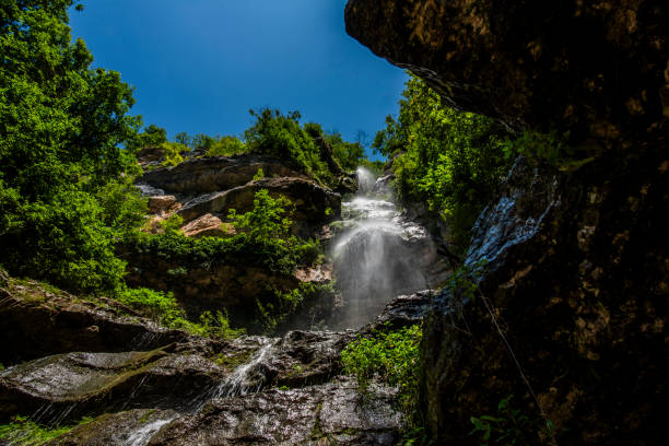 Alpine stream waterfall between woods and pastures in summer in Rotzo on the Asiago plateau Vicenza Veneto Italy