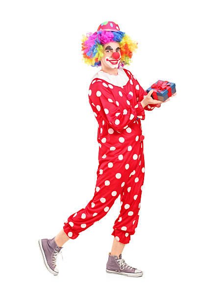 istock Male clown with joyful expression holding a gift 179485726