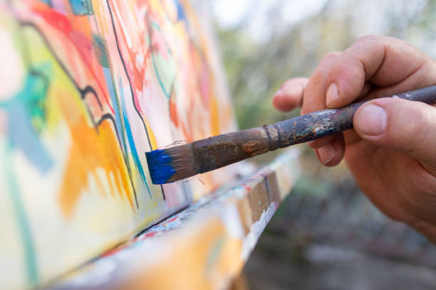 Close-up of an artist- painter working on painting in studio