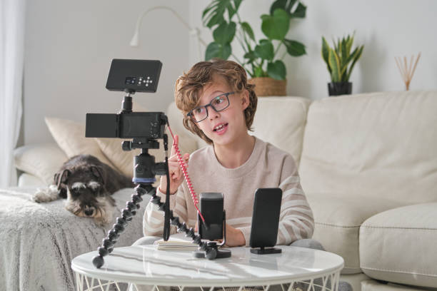 istock Boy pointing up and talking while shooting video at home 1794872910