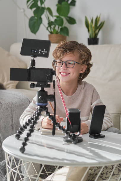 istock Smiling boy shooting video for blog using professional equipment 1794874051