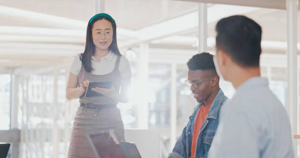 istock Tablet, startup meeting or people brainstorming in office for diversity, planning or digital strategy. Teamwork, laptop or Asian woman in leadership, discussion or conversation for group ideas online 1794895088