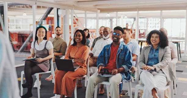 istock Business people, speaker and listening to a presentation, coaching or crowd training in workshop seminar. Group of creative employee designers in the audience for mentor, meeting or at the office 1794895685
