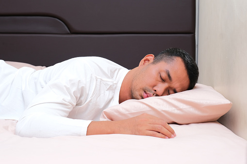 Hombre asiático adulto durmiendo boca abajo photo