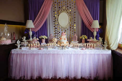 A candy bar with sweets in pink and purple tones for a baby