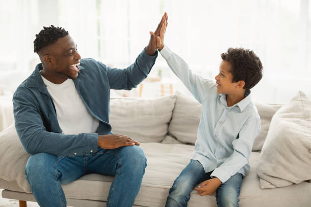 istock African Daddy and Son Giving High Five Celebrating Success Indoors 1794916256