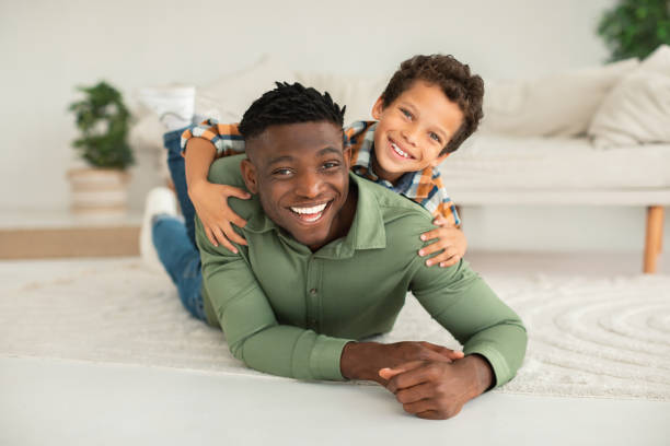istock Joyful African American Daddy And Kid Son Posing Lying Indoor 1794916266
