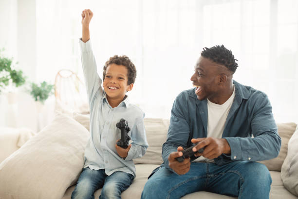 istock Joyful Black Daddy And Son Winning Online Video Game Indoor 1794916274