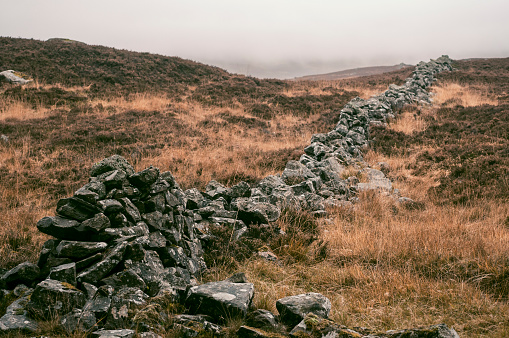 Stone wall in a highland landscape during an overcast autumn day in Perthsire Scotland