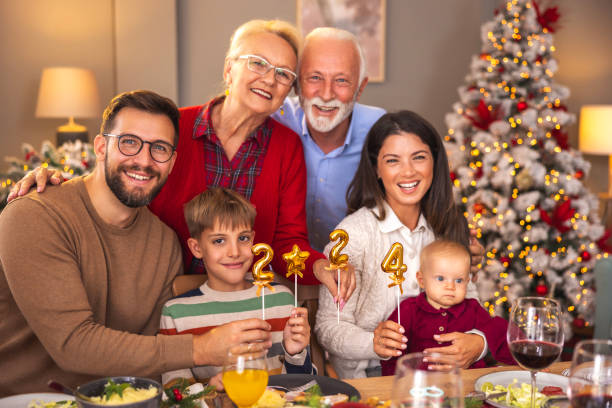istock Multi-generation family holding balloons shaped as numbers 2024 while having Christmas dinner 1794928353