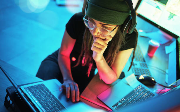 istock Laptop, woman and hacker thinking with music and programming for cybersecurity. Neon top view, headphones and coder reading information for hacking while streaming radio on dark web at night in home. 1794934465