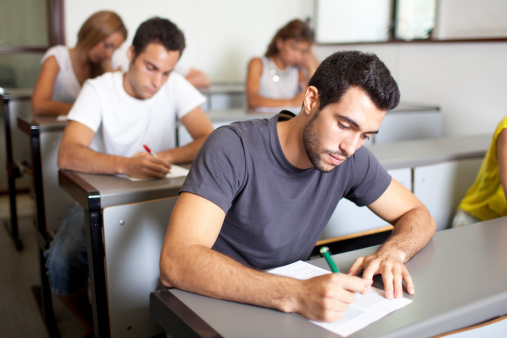 Atractiva macho estudiante escribir un examen photo