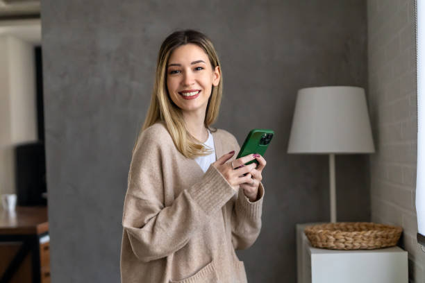 istock Smiling young female using mobile phone app playing game, shopping online, ordering delivery 1794944038