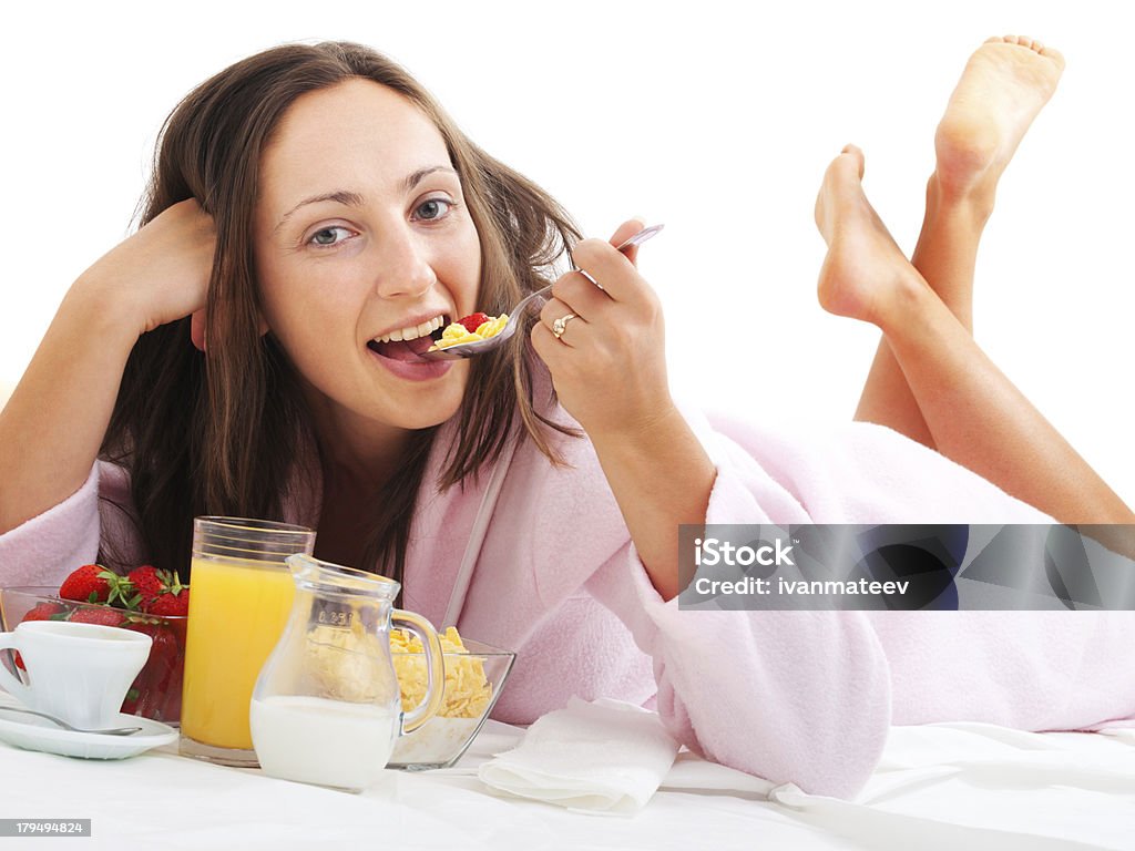 Woman having breakfast in bed Woman having breakfast in bed, isolated on white Adult Stock Photo